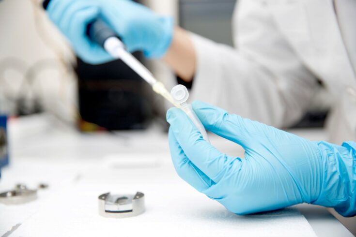 Gloved hands holding a vaccine