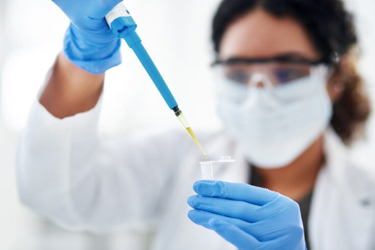 Gloved hands holding a vaccine