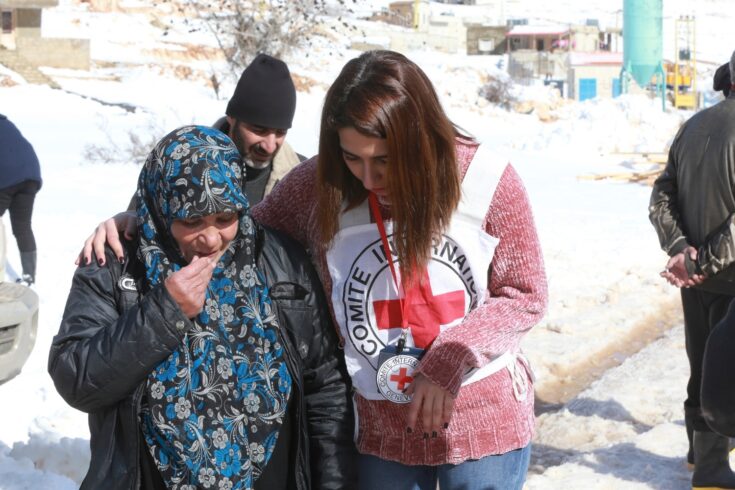 Refugee with member of Red Cross