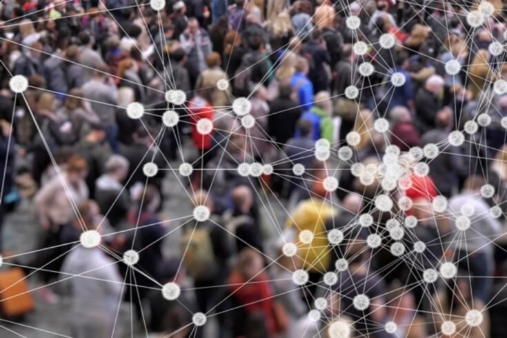 A crowd of people with a network of cells in the front of the frame