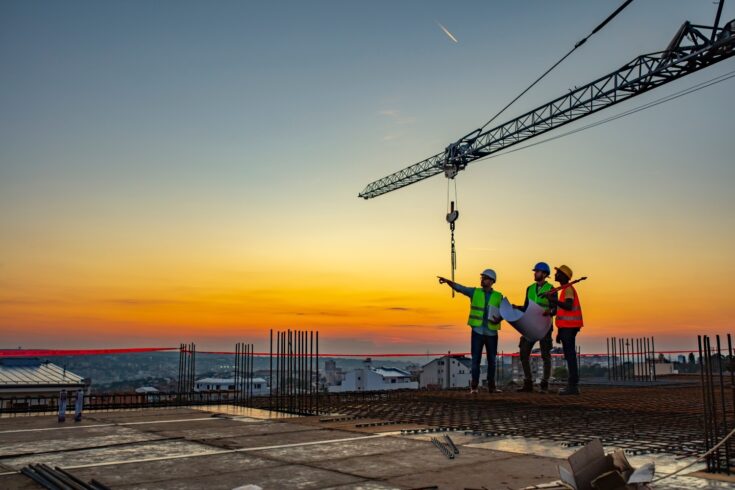 Workers on a construction site with a crane