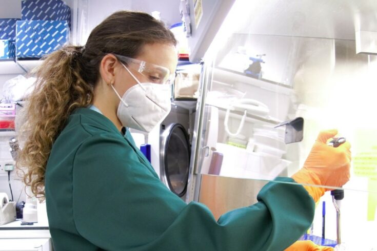 A scientist wearing PPE in a lab