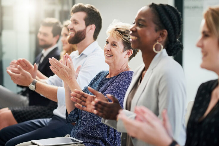 Shot of a mature businesswoman clapping and celebrating with other entrepreneurs at a business conference