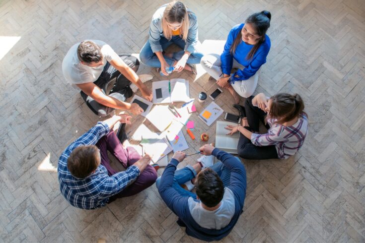 Overhead view on young people sitting on floor