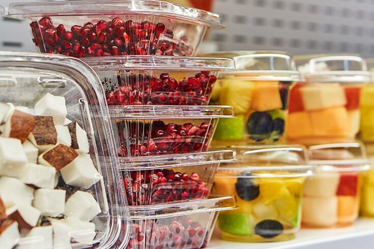 Fruit in plastic containers on supermarket shelf