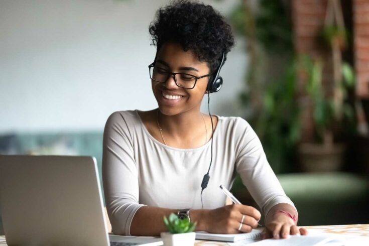 smiling woman making notes and working