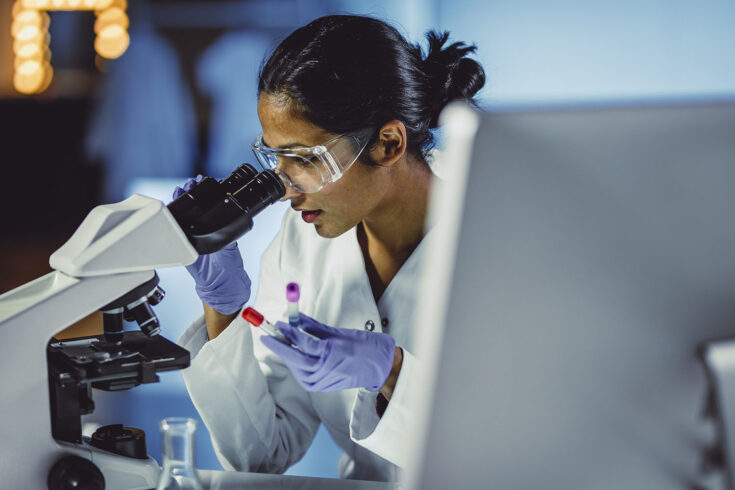 Young scientist looking through a microscope