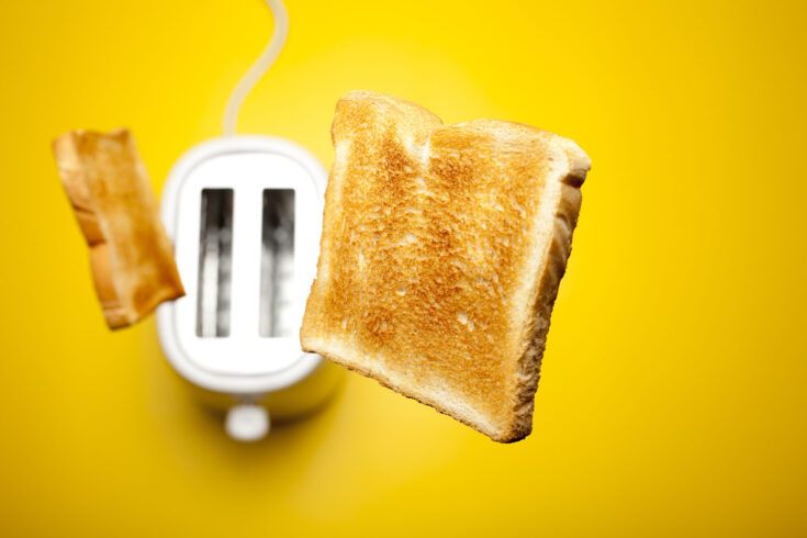 Photograph of fresh toast bread jumping out of the toaster.