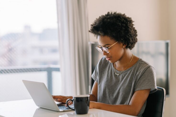 Young black woman using laptop at home