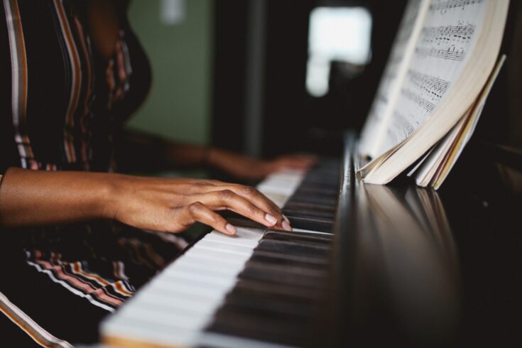 A black pianist's hands playing a piano