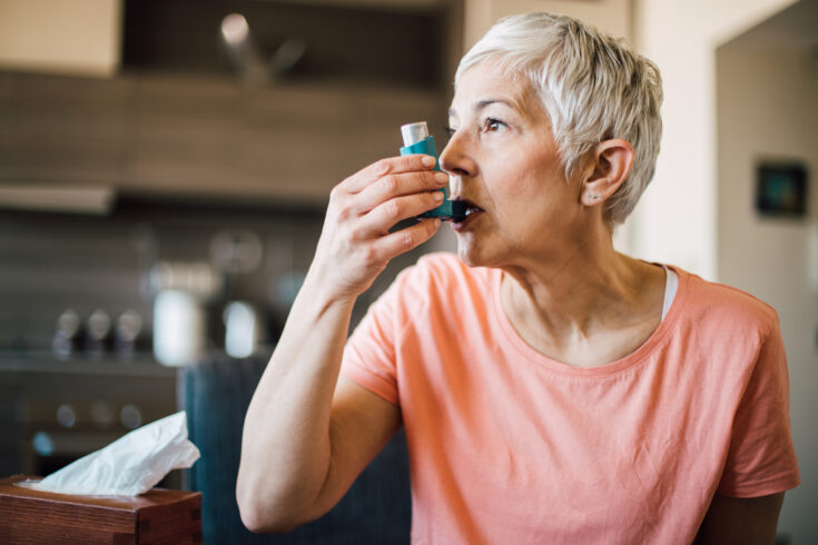 Woman using asthma inhaler