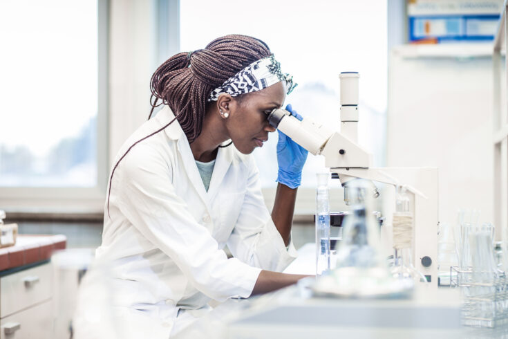 Female Scientist Working in The Laboratory, Using a Microscope