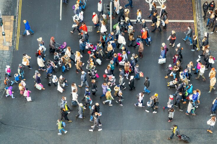 An image, taken from above, of people crossing the road at a busy junction