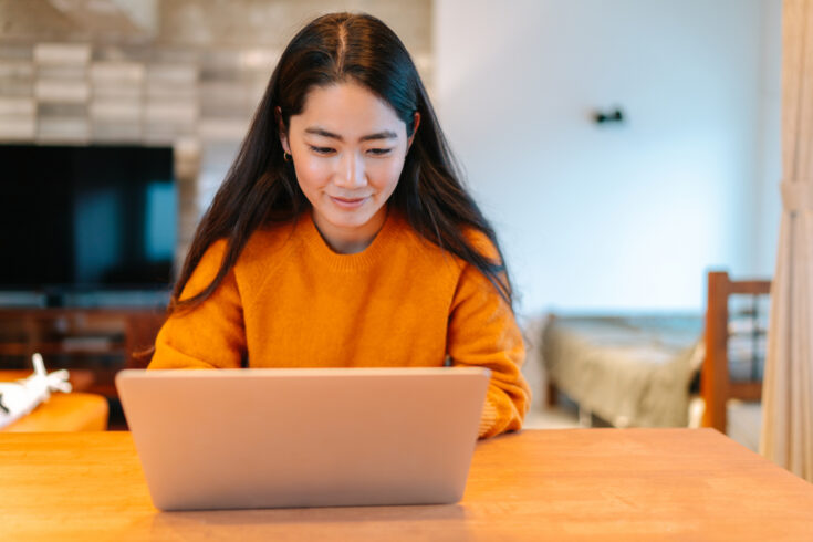 Young stylish woman using laptop at home