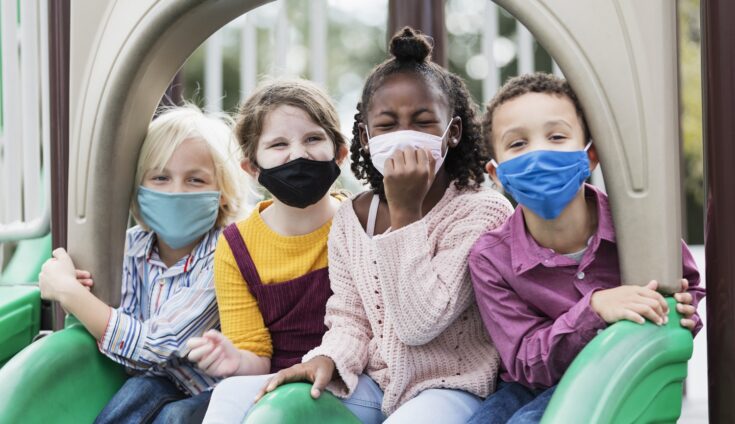 Children on playground wearing face masks, COVID-19