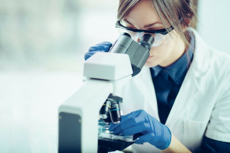 Female scientist using microscope