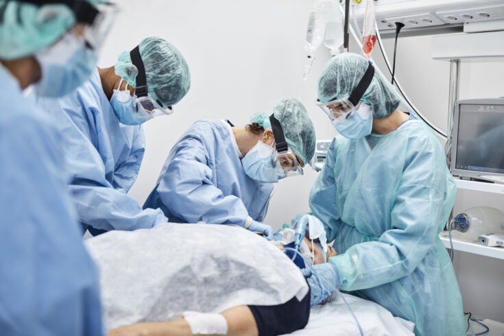 Team of Doctors and Nurses Operating Male Patient