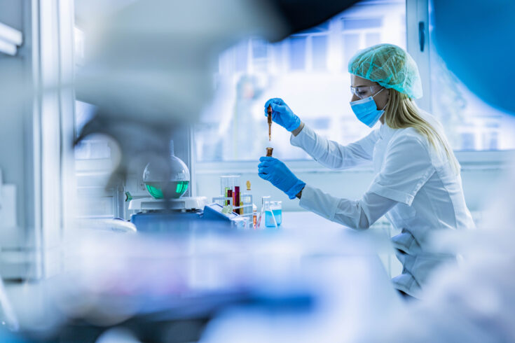 Female scientist examining toxic liquid in laboratory.