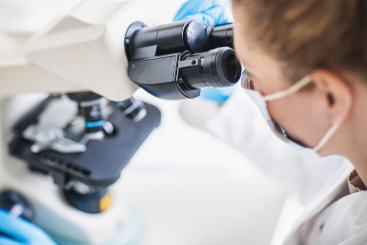 Scientist looking through a microscope