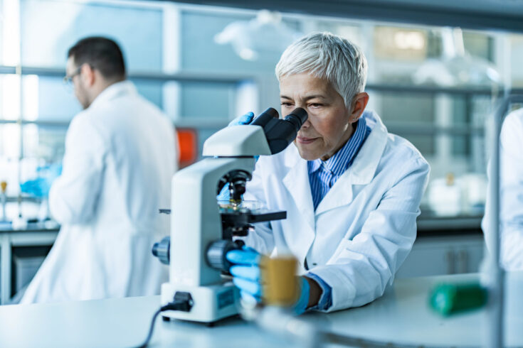 Senior female scientist working on a microscope in laboratory