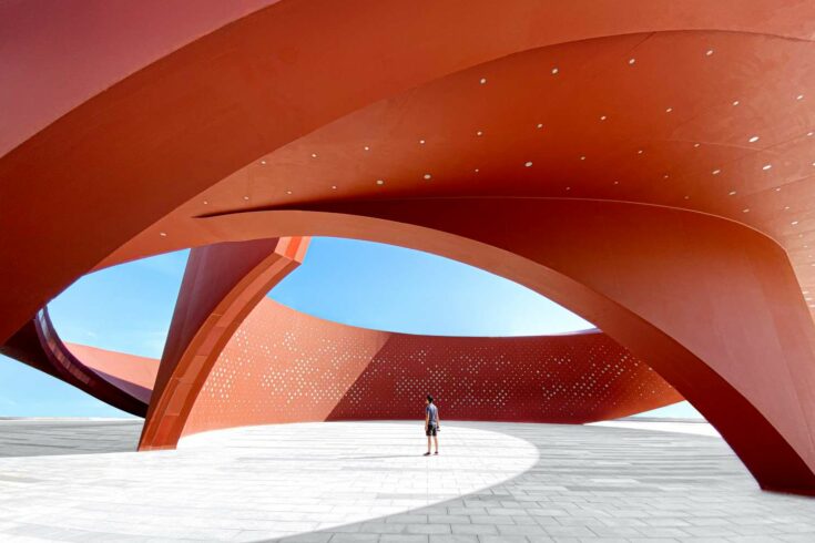 A person in a red curved abstract architectural space