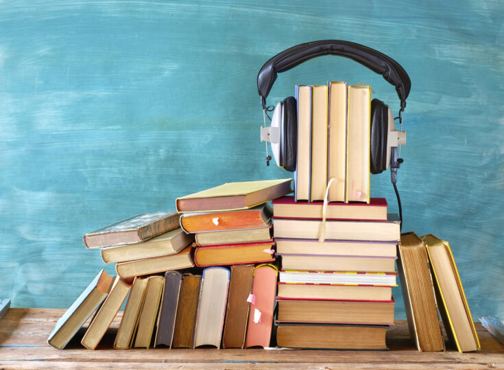 Books piled up with headphones