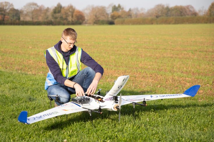 Man with autonomous drone in a field