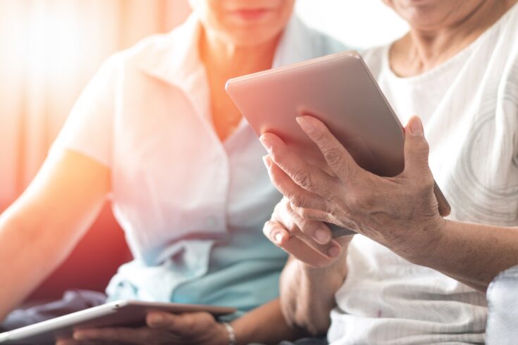 Ageing elderly women using tablet.