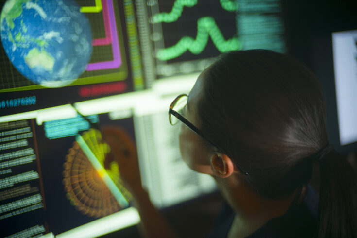 Asian woman staring at a screen with Earth displaying