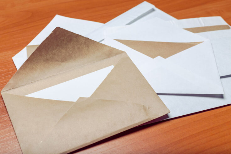 Photo of blank envelope on a wooden background.