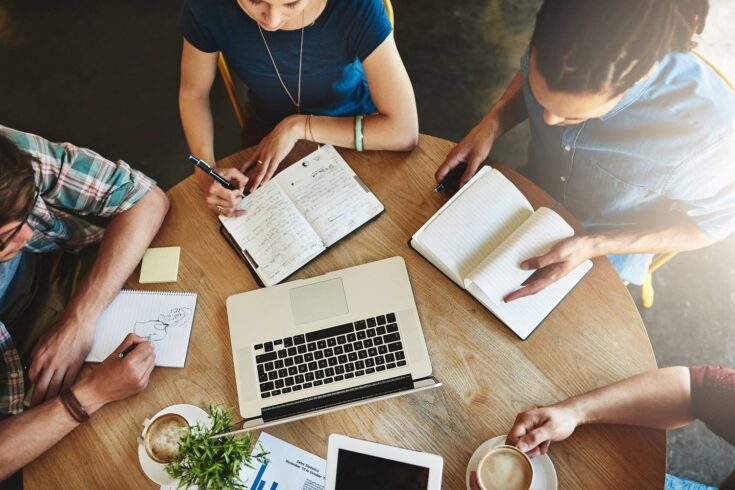 Group of students in discussion at table, from above