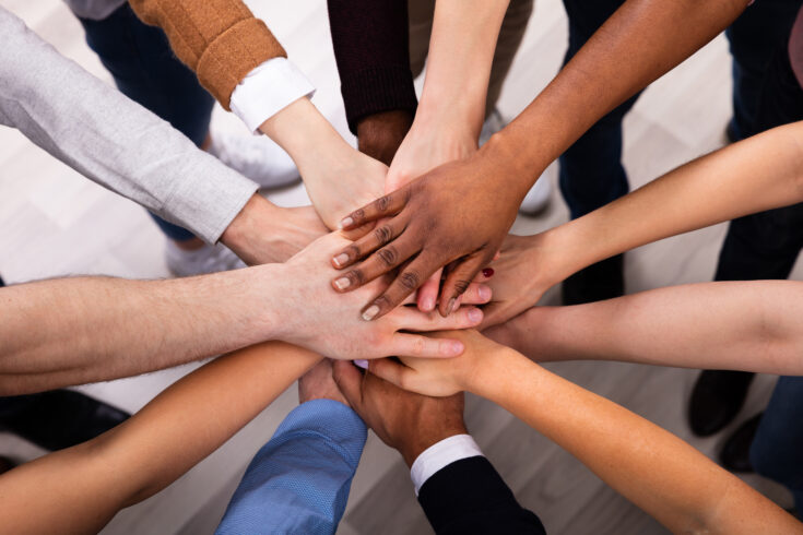 Diverse people stacking hands together