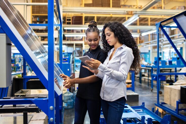 Supervisor and worker discussing work on digital tablet