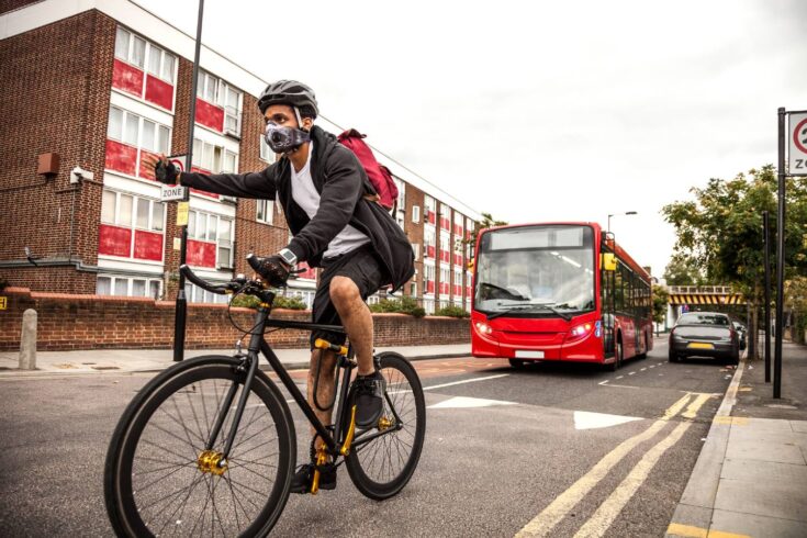 Cyclist commuter wearing a pollution-mask in Central London - stock photo