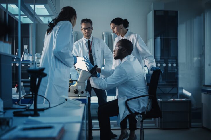 Medical Science Laboratory with Diverse Multi-Ethnic Team of Microbiology Scientists Have Meeting on Developing Drugs, Medicine, Doing Biotechnology Research. Working on Computers, Analyzing Samples