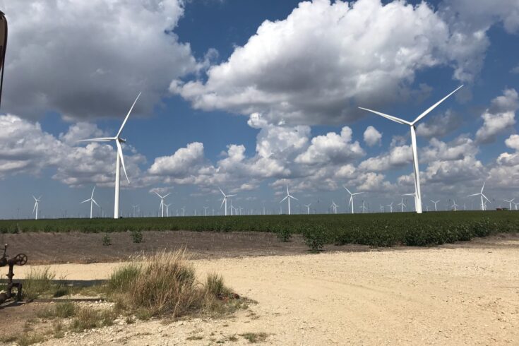 Blue sky, white clouds and a field of countless wind turbines