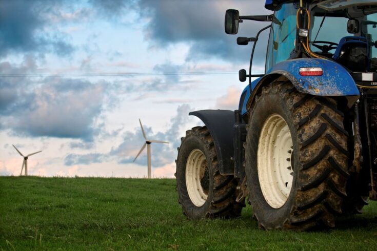 Tractor in field of wind farm turbines in Cornwall