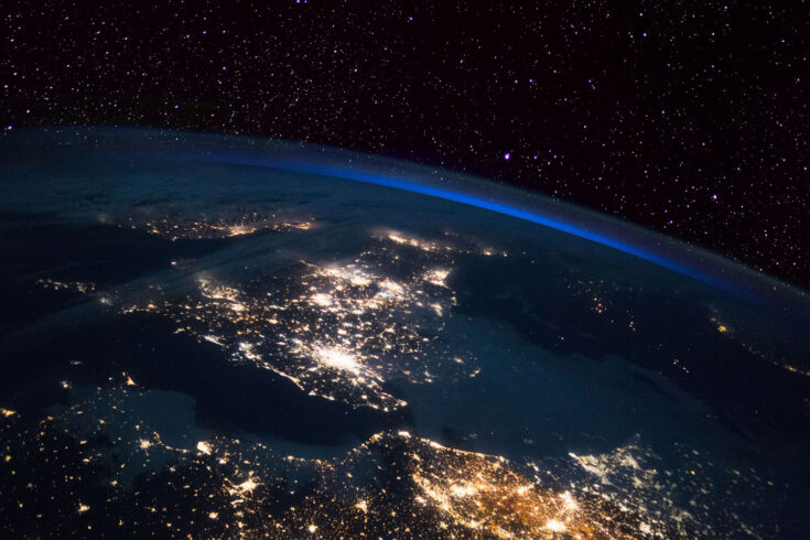 Earth showing the UK at night from the International Space Station (ISS) with France and Holland in the foreground.