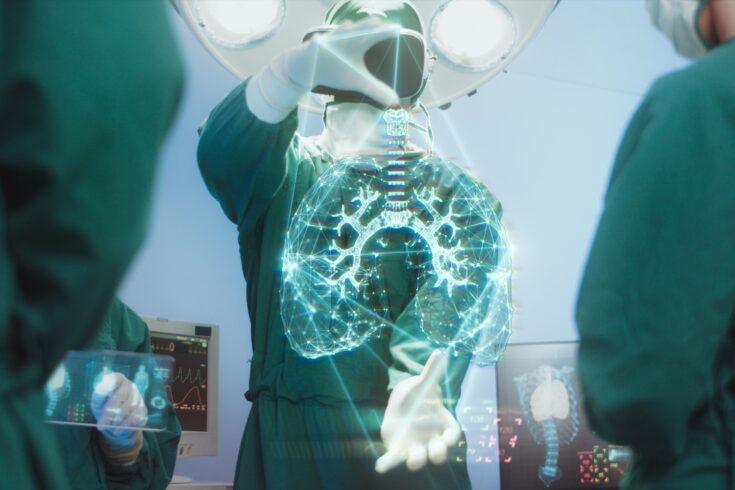 Team of surgeons in the operating room using hi-tech modern virtual reality simulator interface with hologram