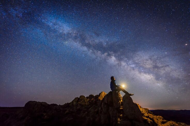 Man sitting under the Milky Way Galaxy