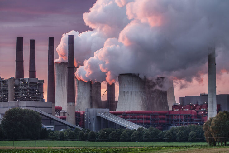 Industry in dramatic red sunset light. Chimneys and cooling tower of a coal fired power station.
