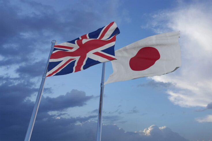 National flags of the UK and Japan waving in the sky