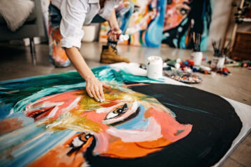 Female artist painting portrait on canvas.