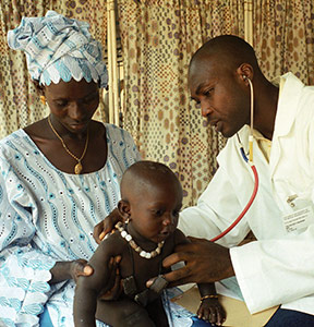 African doctor examining a small child