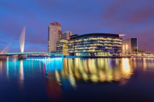 BBC media city building at Salford Quays reflecting in the water at night