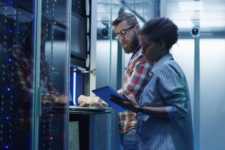 Diverse IT colleagues setting server hardware.