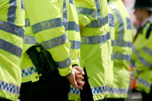 close up image of row of police standing with their backs facing to us