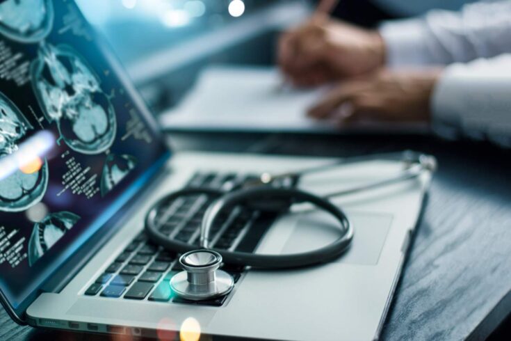 brain test result on the laptop screen and stethoscope on the laptop keyboard.