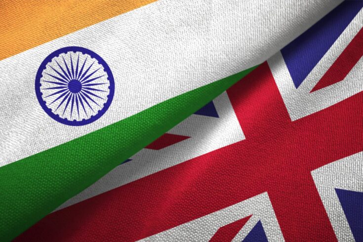 UK and India flags together in a textile cloth fabric texture