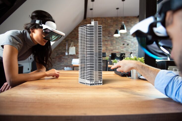 Two people working on virtual 3d building by using AR glasses.